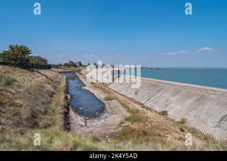 Blick entlang der Betonwand/Pfad Nordküste der Isle of Sheppy in Richtung Centre Bastion Battery bei Sheerness, Kent, Großbritannien. Stockfoto