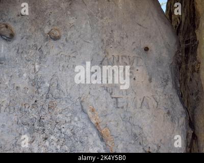 Graffiti kratzten sich im Coty House des Kits, einer megalithischen Grabkammer für „Dolmen“ in der Nähe von Aylesford, Kent, Großbritannien. Stockfoto