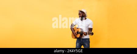 In voller Länge Foto von Angeregten künstlerische Mann, der seine Gitarre spielen. Auf gelben Hintergrund. Stockfoto