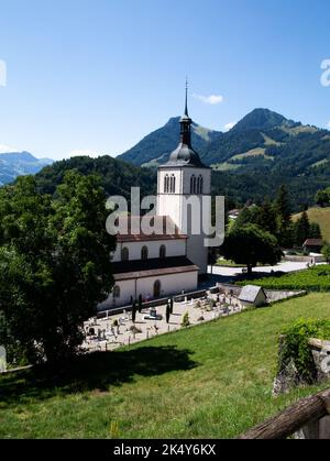 Eglise Saint Theodule in Gruyeres Schweiz mit den Bergen im Hintergrund Stockfoto