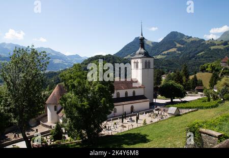 Eglise Saint Theodule in Gruyeres Schweiz mit den Bergen im Hintergrund Stockfoto