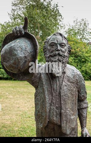 Deutschland, Lübeck - 13. Juli 2022: Gesichtsaufnahme der schwarz-grünen Bronzestatue von Johannes Brahms im grünen Garten unter grauem Himmel auf Obertravenbrücke, Stockfoto