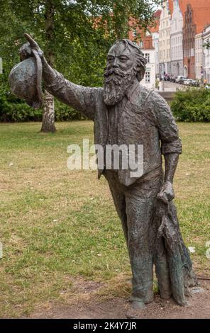 Deutschland, Lübeck - 13. Juli 2022: Nahaufnahme der schwarz-grünen Bronzestatue von Johannes Brahms im grünen Garten unter grauem Himmel auf der Obertravenbrücke, Stockfoto