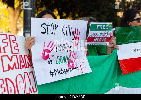 Barcelona, Spanien. 04. Oktober 2022. Ein Protestler hält während der Demonstration ein Plakat mit der Aufschrift „Stoppt das Töten von Menschen im Iran“. Ähnliche Demonstrationen wurden in Städten auf der ganzen Welt abgehalten, um Gerechtigkeit für die Tötung von Mahsa Amini zu fordern, einer jungen Frau, die von der iranischen Moralpolizei in Teheran inhaftiert wurde, weil sie den Hijab nicht ordnungsgemäß in der Öffentlichkeit trug. Kredit: SOPA Images Limited/Alamy Live Nachrichten Stockfoto