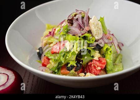 Griechischer Salat auf einem Teller. Geringe Schärfentiefe Stockfoto