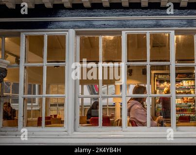 Weibliche Fahrgastin wartet im Wartezimmer auf der Treppe am Bahnhof von York. Stockfoto