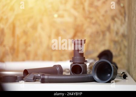 Klempner Werkzeuge und Wasserhahn bereit für die Installation in der Nähe von Waschbecken auf Arbeitsplatte in der Küche. Anschlüsse für den Einbau des Wasserhahns für den k Stockfoto