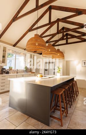 Gesamtansicht der modernen Küche mit Arbeitsplatte, Stühlen und Küchenausstattung. Haus Interieur und Design-Konzept. Stockfoto