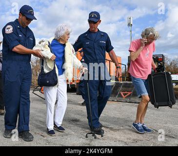 Chris Taylor, Chief Petty Officer der US-Küstenwache, und Ryan Owen, 1.. Klasse, unterstützen eine Residenz in Pine Island, Florida, 4. Oktober 2022. Die Streikkräfte brachten Menschen in Not auf das Festland Floridas, um Schutz und Ressourcen zu suchen. Foto der US-Küstenwache von Petty Officer 3. Klasse Ian Gray. Stockfoto