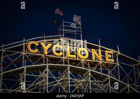 New York, NY - USA - 3. September 2022 nächtliche horizontale Ansicht des ikonischen, beleuchteten Coney Island Cyclone-Schildes; montiert auf der Holzrolle Stockfoto