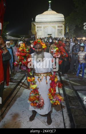 Lahore, Punjab, Pakistan. 4. Oktober 2022. Pakistanische muslimische Anhänger zünden Kerzen an Erdöllampen an und Devotes (Malang) tanzen am Schrein des berühmten Sufi-Heiligen Hazrat mir Mohammed Muayyinul aus dem 15. Jahrhundert während der 399. URS-Geburtstagfeier in Lahore. Tausende von Menschen im ganzen Land besuchen den Schrein, um ihm während eines dreitägigen Festivals Tribut zu zollen. Der heilige war unter den muslimischen und den Sikh-Religionen gleichermaßen beliebt, als Mian mir im Dezember 1588 nach Amritsar (Indien) ging, um den Grundstein für Sikhs heiligste Stätte, den Goldenen Tempel, der allgemein als Sri bekannt ist, zu legen Stockfoto