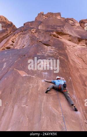 Männlicher Kletterer auf Sandsteinklippen bei Moab, Utah Stockfoto