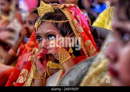 Kalkutta, Indien. 04. Oktober 2022. Ein kleines Mädchen sah während des Kumari Puja Rituals, wie es sich mit ihren Ornamenten fertig machte. Kumari Puja ist eine indische Hindu-Tradition, die hauptsächlich während der Durga Puja nach dem Hindu-Kalender gefeiert wird. Die philosophische Grundlage von Kumari Puja besteht darin, den Wert von Frauen zu ermitteln. Eifrige Anhänger glauben, dass sie alle Barrieren und Gefahren für die jungen Mädchen in der kommenden Zukunft überwinden werden, und sie werden auch befugt sein, jeden Stress und jede Behinderung in ihrem kommenden Leben zu bewältigen. Kredit: SOPA Images Limited/Alamy Live Nachrichten Stockfoto