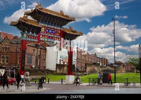 Newcastle-upon-Tyne, England, Vereinigtes Königreich.  Chinatown Eingangsbogen, St. Andrews Street.  Reste des 13. Jahrhundert Stadtmauer in mittlerer Entfernung. Stockfoto