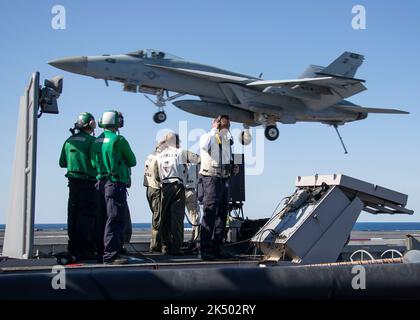 DER ATLANTISCHE OZEAN (11. April 2022) Matrosen, die dem Flugzeugträger USS Gerald R. Ford (CVN 78) und Carrier Air Wing (CVW) 8 zugewiesen wurden, stehen auf der Plattform des Sicherheitsbeauftragten der Landung unter Beobachtung, während sich ein E/A-18G Growler, der an den „Grauen Wölfen“ des Elektronischen Angriffsgeschwaders (VAQ) 142 befestigt ist, dem Flugdeck nähert. 11. April 2022. Gerald R. Ford führt derzeit im Atlantischen Ozean die Qualifizierung von Fluggesellschaften und die Integration von Streikgruppen als Teil der shipÕs Tailored Basic Phase vor dem operativen Einsatz durch. (USA Navy Foto von Mass Communication Specialist 3. Class Jackson Adkins) Stockfoto