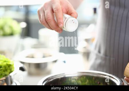 Koch salzen kochendes Wasser oder Lebensmittel in Kochtöpfen Stockfoto