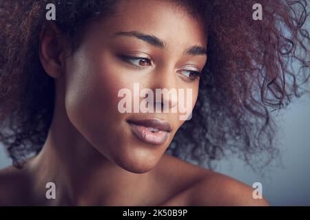 Natürliche wunderschöne Locken. Kopf- und Schulteraufnahme einer schönen afrikanischen Frau mit lockigen Haaren. Stockfoto