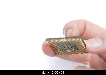 Mann, der Computer-CPU mit den Fingern hält, Nahaufnahme auf weißem Hintergrund mit Kopierplatz Stockfoto