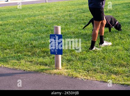 Ein Mann mit Hund verstößt gegen das Verbot von Wanderhunden in einem New Yorker Park Stockfoto