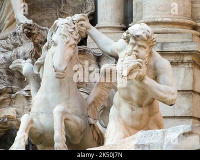 Nahaufnahme des Trevi-Brunnens. Skulptur von Triton, die ein fliegendes Pferd führt. Fontana di Trevi, Rom, Italien. Selektiver Fokus und Rauschen inklusive. Stockfoto
