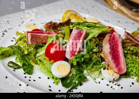 Nicoise-Salat mit mittelgeröstetem Thunfisch, gemischtem Salat und Wachtelei Stockfoto