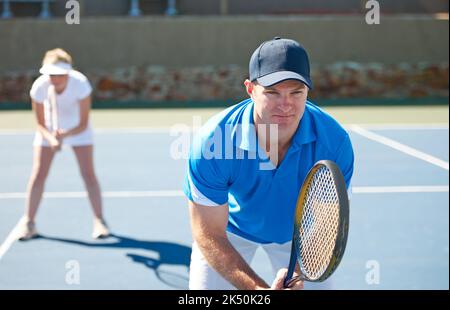 In Position. Ein gemischtes Doppelteam steht bereit, einen Aufschlag zu erhalten - Tennis. Stockfoto