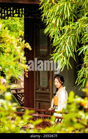 Ein Mädchen, das in traditioneller Kleidung auf dem Gelände des UNESCO-Weltkulturerbes für Paare in Suzhou, Provinz Jiangsu, China, gekleidet ist. Stockfoto