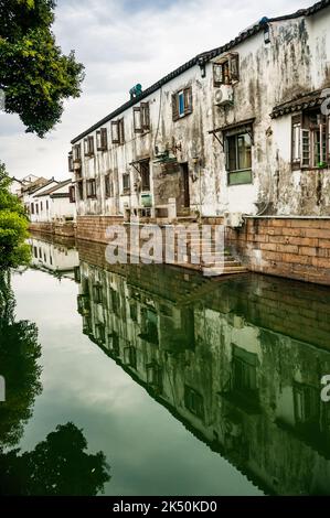 Ein Gebäude an einem Seitenkanal vor der Pingjiang Lu eine Straße voller alter Gebäude in Suzhou, Provinz Jiangsu, China. Stockfoto