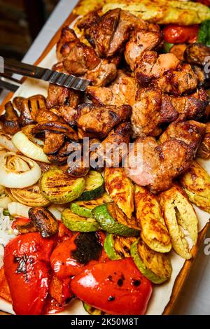 Shish Kebab mit gegrilltem Gemüse, Lavasch und Saucen. Nahaufnahme, selektiver Fokus Stockfoto