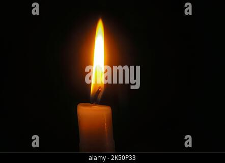 Nahaufnahme von Kerzenflamme im Dunkeln. Stockfoto