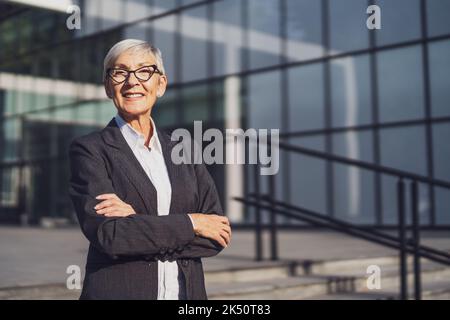 Außenportrait einer erfolgreichen Geschäftsfrau vor dem Firmengebäude. Stockfoto