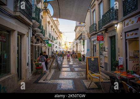 Faro, Portugal, September 2022: Blick auf eine gemütliche Straße mit Restaurants und Bars in der Altstadt von Faro. Stockfoto