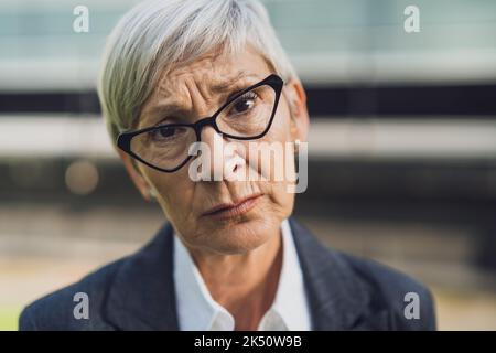 Nahaufnahme des Porträts einer älteren Geschäftsfrau, die traurig und besorgt ist. Stockfoto