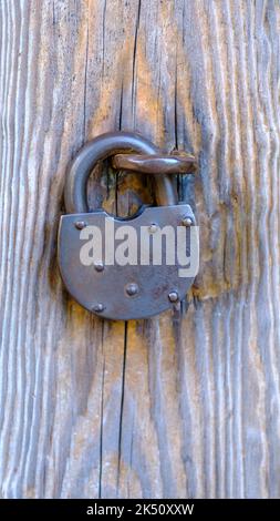 Ein großes altes Türschloss. Alte Holztür verriegelt. Horizontal. Stockfoto