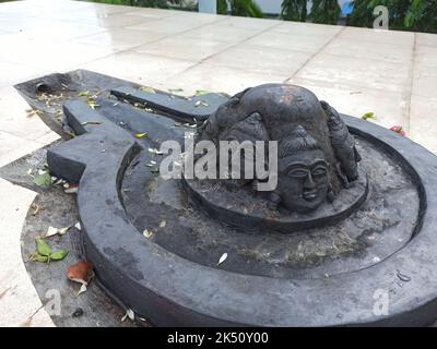 Eine Shiva Linga, die mit einem schwarzen Stein auf einer Ebenen Oberfläche mit einer Umgebung aus Fliesen hergestellt wurde Stockfoto