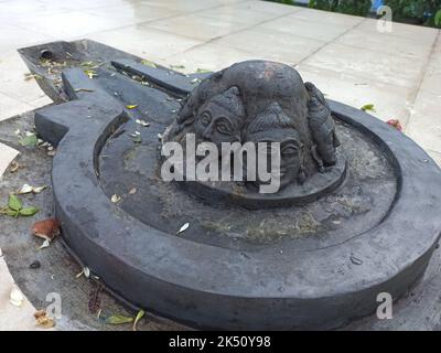 Eine Shiva Linga, die mit einem schwarzen Stein auf einer Ebenen Oberfläche mit einer Umgebung aus Fliesen hergestellt wurde Stockfoto