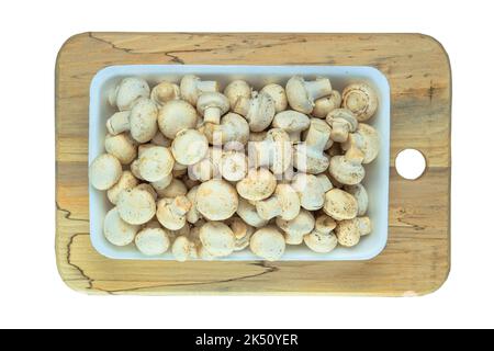 Pilze in einem weißen Behälter auf einem Holzbrett isoliert auf einem weißen Hintergrund. Stockfoto