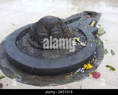 Eine Shiva Linga, die mit einem schwarzen Stein auf einer Ebenen Oberfläche mit einer Umgebung aus Fliesen hergestellt wurde Stockfoto