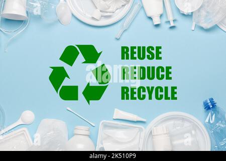 Recycling-Sybmol mit Reuse Reduce Recycle Slogan umgeben von Einweg-Kunststoffobjekten, Verpacken von Kunststoffabfällen Produkte Draufsicht Stockfoto