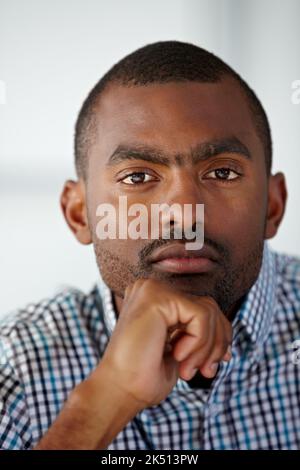 HES hat das Zeug zum Erfolg. Porträt eines ernsthaften afroamerikanischen Mannes, der vor weißem Hintergrund denkt. Stockfoto