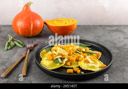 Saisonales Herbstrezept. Kürbisravioli mit Salbei, Parmesan und Olivenöl. Stockfoto