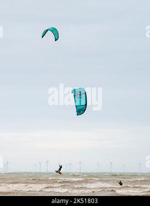 Worthing UK 5. October 2022 - Kitesurfer machen das Beste aus dem windigen Wetter am Strand von Worthing in West Sussex heute : Credit Simon Dack / Alamy Live News Stockfoto