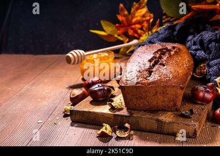 Hausgemachter Kastanienkuchen, süßes veganes Schokoladenkastanienbrotbrot mit Honig und Karamellsauce Stockfoto