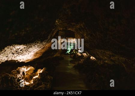 Enger Pfad durch dunkle Felsenhöhle, beleuchtet mit Lampen im Inneren des Berges Stockfoto