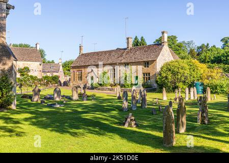 Im Hochsommer wird am frühen Morgen die Grundschule der Church of England aus dem 19.. Jahrhundert im Cotswold-Dorf Bibury, Gloucestershire, England, beleuchtet Stockfoto