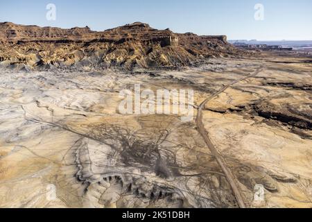 Atemberaubende Drohnenansicht von unwegsamem, unwegsamem Gelände in der Nähe des Glen Canyon National Recreation Area unter wolkenlosem, blauem Himmel in Utah Stockfoto