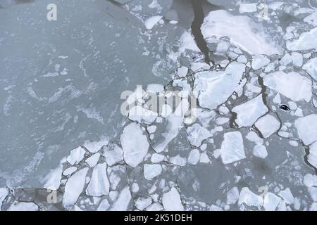 Atemberaubende Drohnenansicht des mit rissem Eis bedeckten Meeres und des Vatnajokull-Gletschers in Island Stockfoto