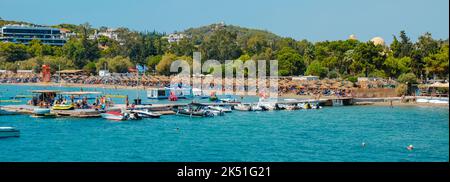 Vouliagmeni, Griechenland - 1. September 2022: Panoramablick auf den Strand von Vouliagmeni in Vouliagmeni, Griechenland, an einem Sommertag Stockfoto