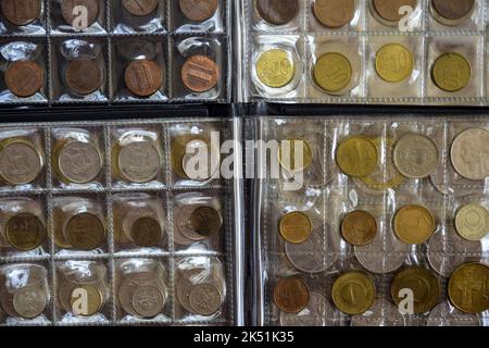 Сoins verschiedener Länder sind in transparenten Blasen angeordnet. Seite aus Album voll mit alten Münzen. Münzaufbewahrung. Numismatische Sammlung. Fotolia Stockfoto