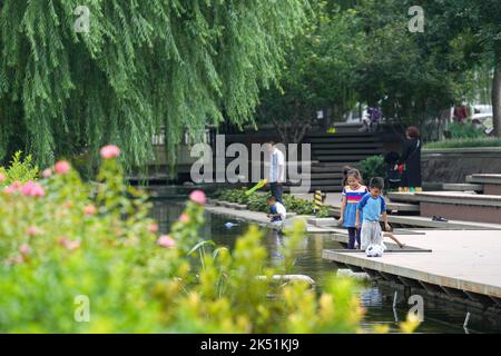 (221005) -- PEKING, 5. Oktober 2022 (Xinhua) -- am 29. August 2022 spielen Menschen auf dem Dongcheng-Abschnitt des Yuhe-Flusses in Peking, der Hauptstadt Chinas. Laut der National Cultural Heritage Administration haben die chinesischen Behörden geplant, die Pekinger Zentralachse als Chinas Bewerbungsprojekt für das Weltkulturerbe im Jahr 2024 zu empfehlen.die Pekinger Zentralachse ist 7,8 Kilometer lang, Ausgehend vom Yongding Gate im Süden der Stadt und endend mit dem Drum Tower und dem Glockenturm im Norden. Die meisten der großen Altstadtgebäude von Peking befinden sich entlang dieser Achse. Die zentrale Achse ist die BA Stockfoto